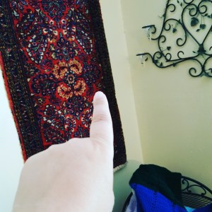 me pointing at a rug on my wall