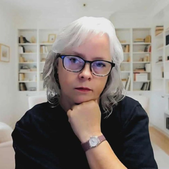 A headshot of author Mandy Webster with a bookcase in the background.